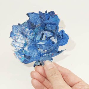 blaue Blumenskulptur aus Stoffschnipseln und Nähfaden